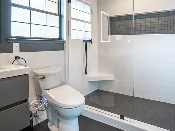 Modern bathroom remodel in California with white and gray shower tiles, walk-in shower with nice, and smart toilet