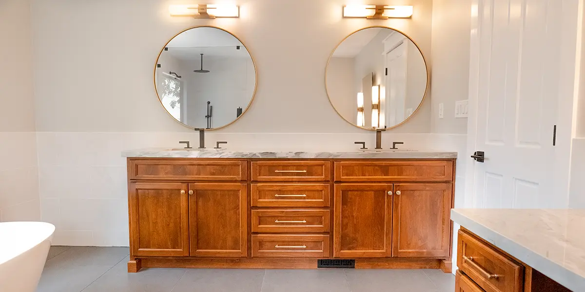 Wood bathroom vanity with double sinks and double circular mirrors