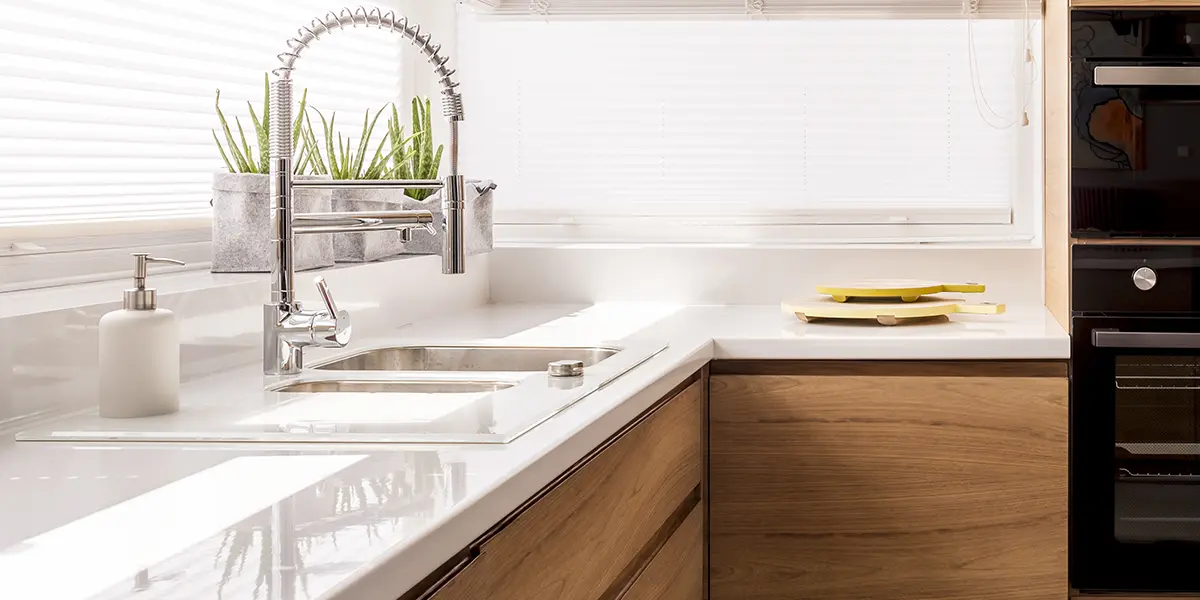New stainless steel faucet in a white and wood kitchen