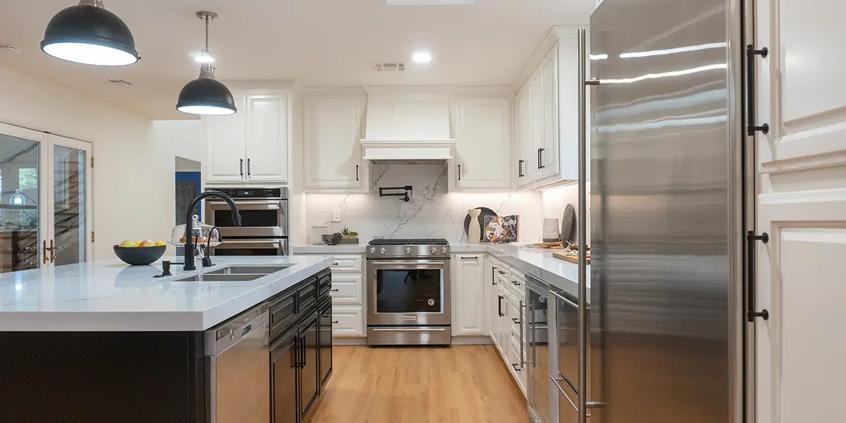 Modern kitchen with black island, white cabinets, and silver appliances