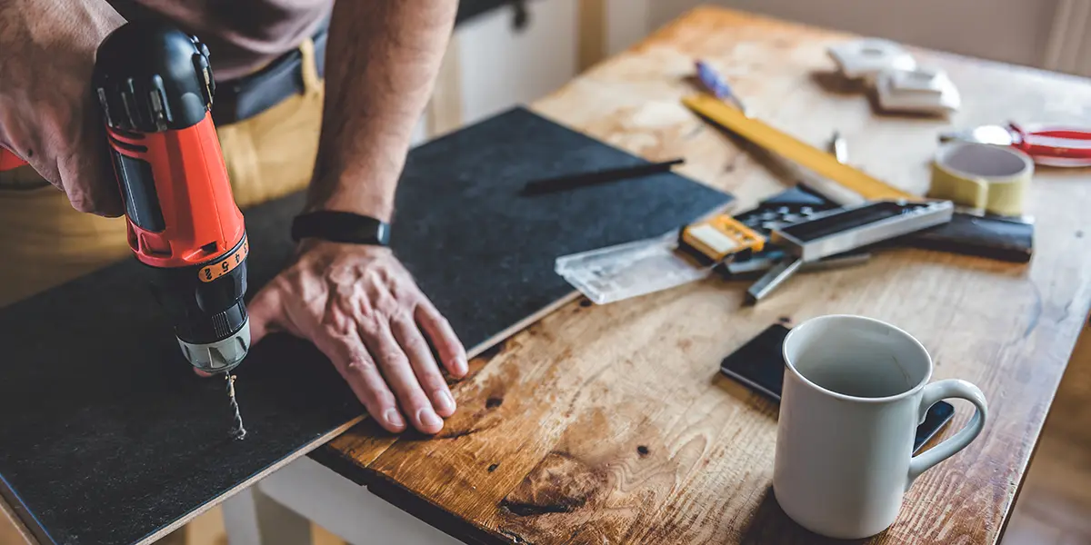 Man using drill on a wood board, DIY project for home renovation