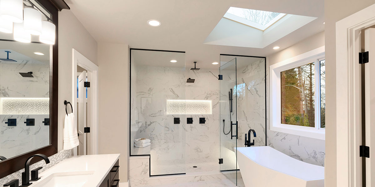 Large bathroom with glass walk-in shower, freestanding tub, and double wood vanity