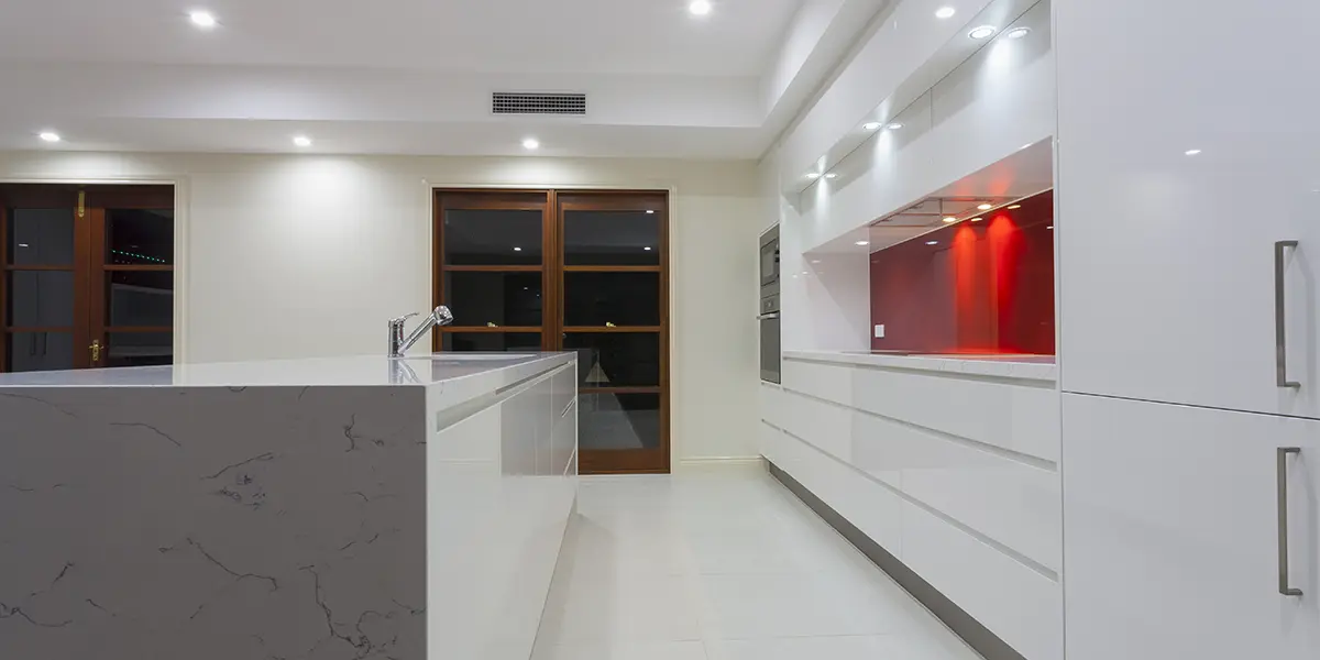 Concealed kitchen with minimalist cabinets and clean white look