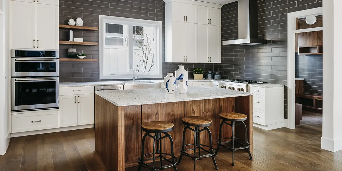 New kitchen renovation with wooden island, black subway backsplash, and white cabinets