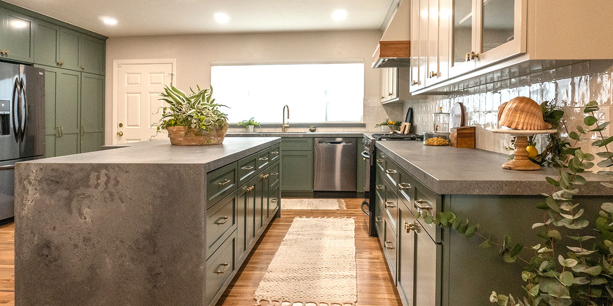 New kitchen with green overlay cabinets and elegant waterfall island