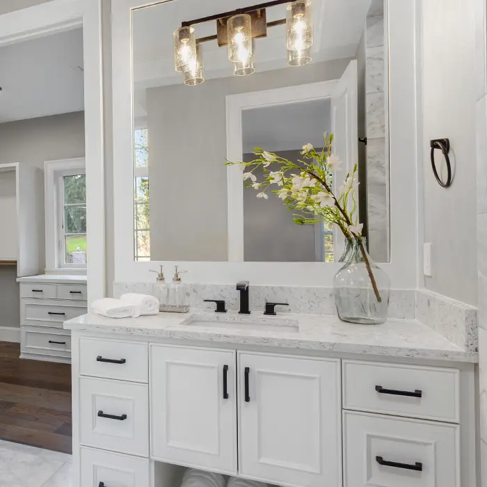 White bathroom with white vanity and black vanity handles