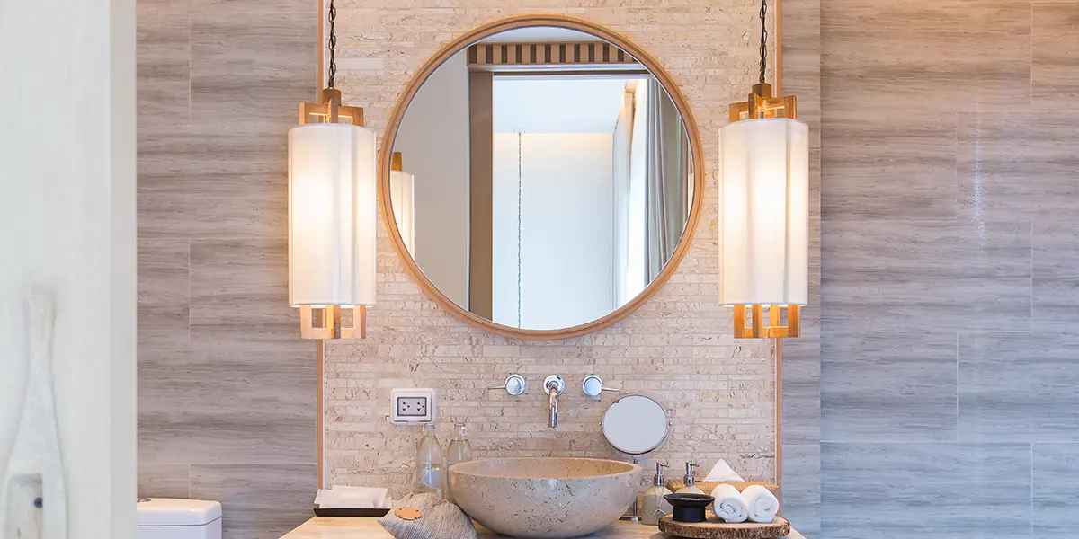 Elegant pendant lights in an organic-looking bathroom with wood and stone tile