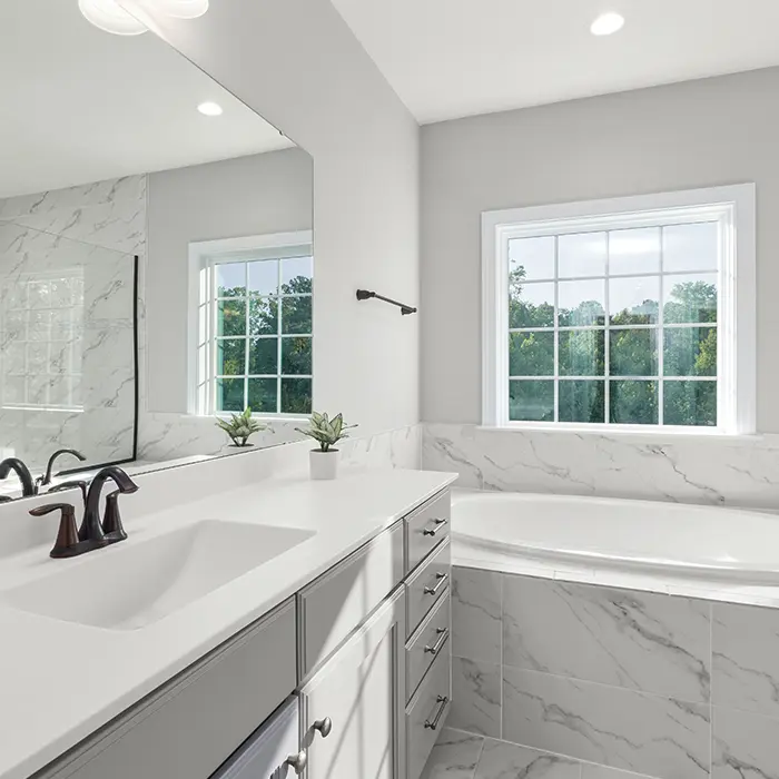 New bathroom after remodel from KHB Construction with marble tile and gray vanity