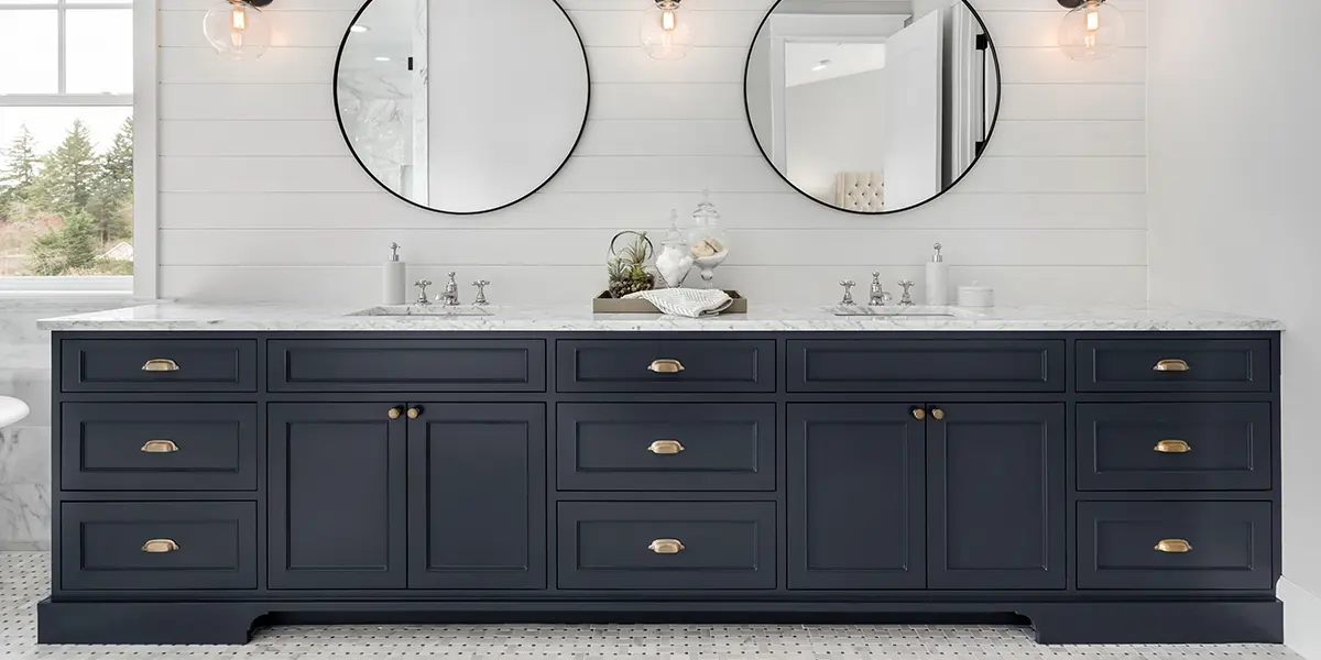 Black vanity in a bathroom with large mirrors