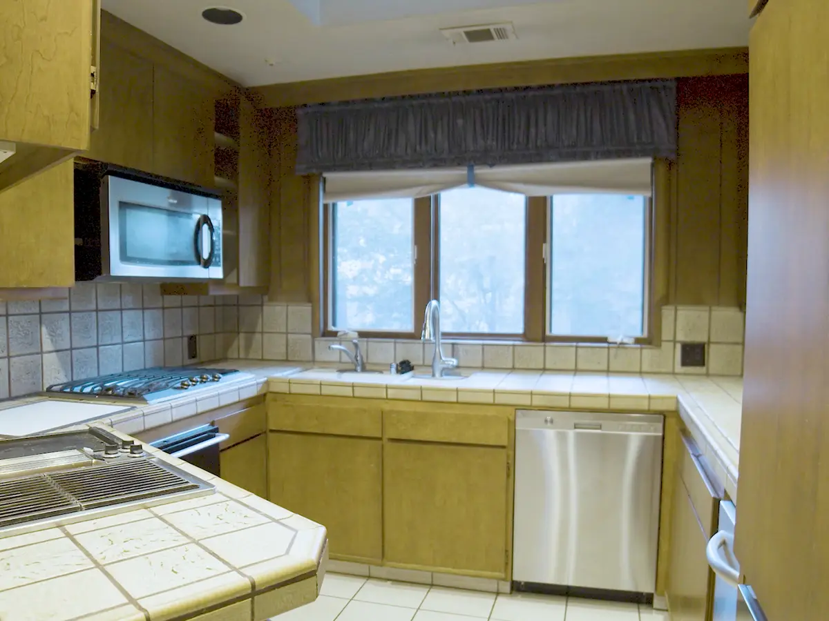 An old kitchen with wood cabinets with no hardware