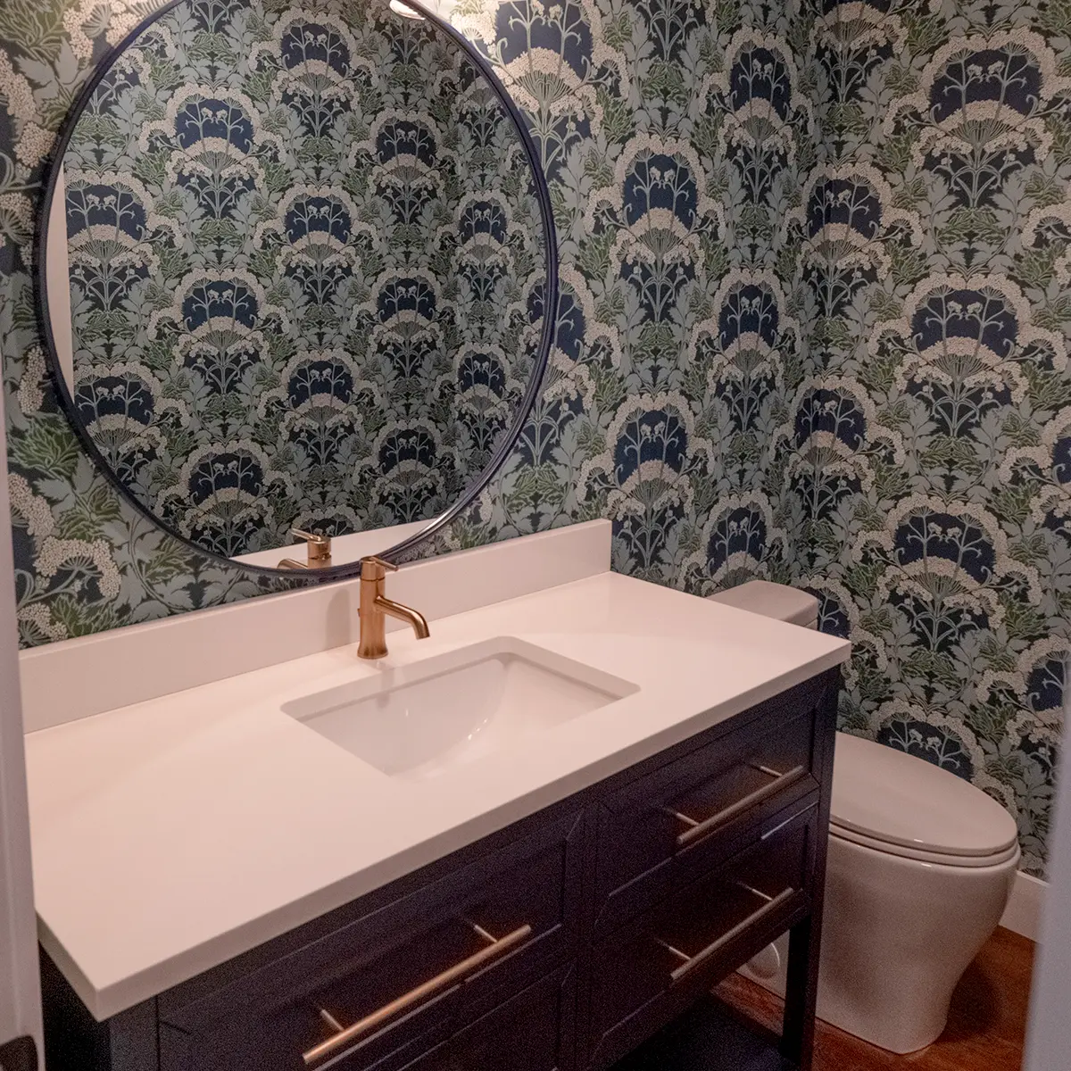 A powder room with a beautiful vanity and wallpaper