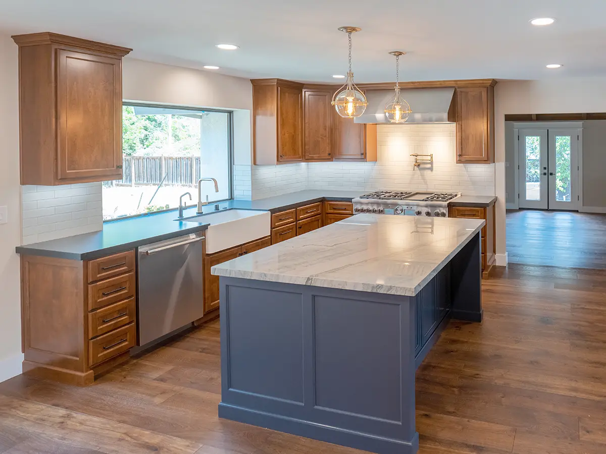 A gray kitchen island with wood kitchen cabinets