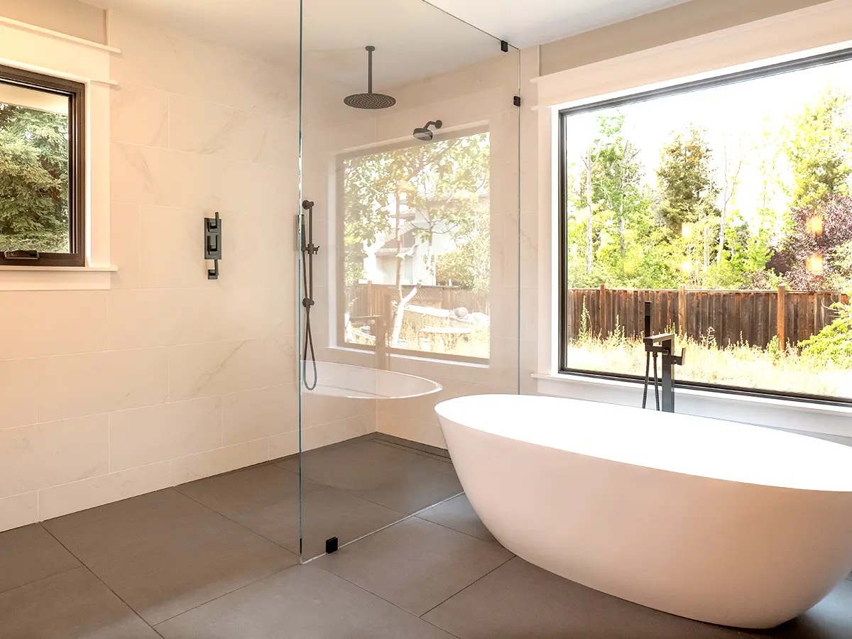 A free standing tub and a glass walk-in shower