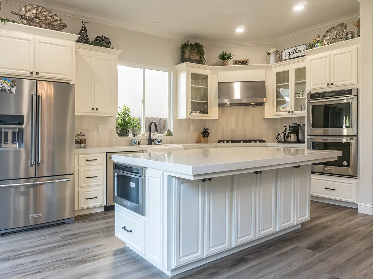 LVP flooring in a kitchen with white cabinets and many ornaments