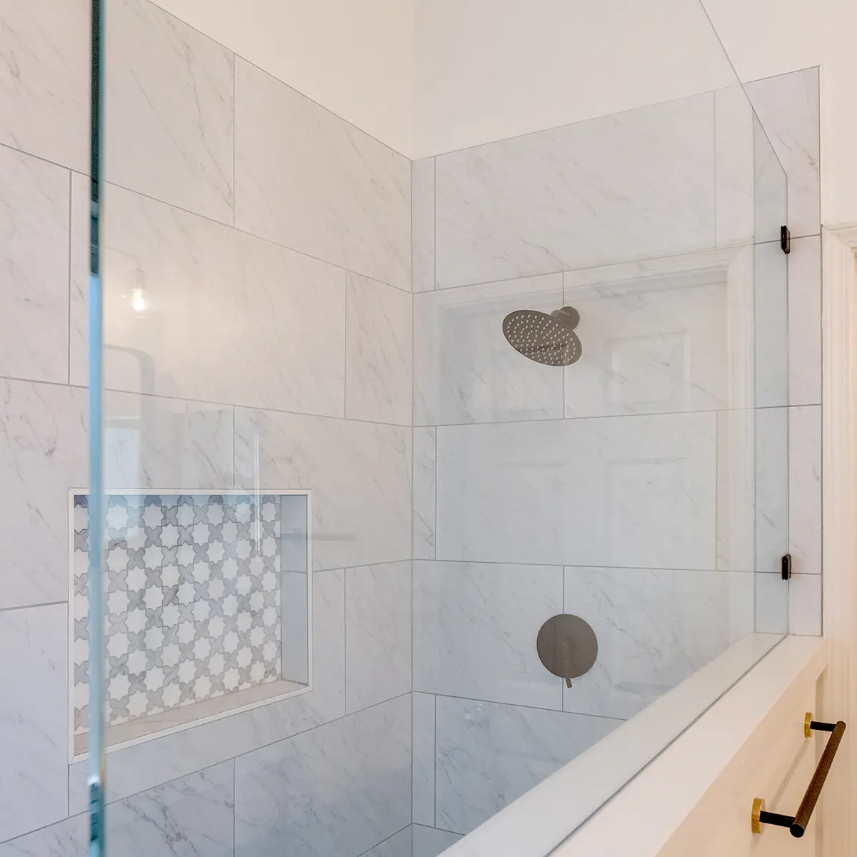 A new walk-in shower with white large tile surround