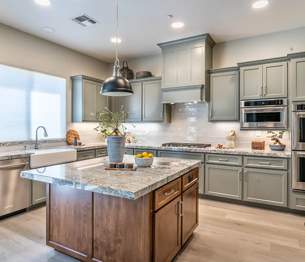 light gray cabinets with a kitchen island that has a granite counter