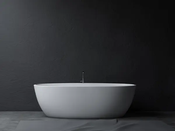 A black bathroom with a white freestanding tub