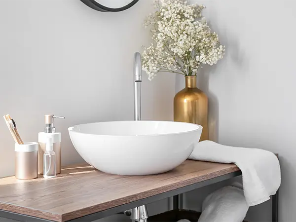 A simple vessel sink with a vase of flowers