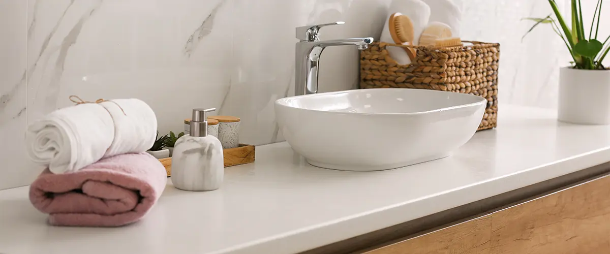 A white countertop and a porcelain bowl sink