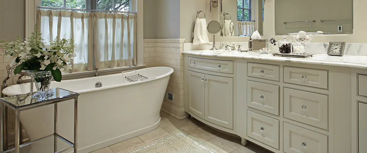 A traditional bathroom with white cabinets and a large tub