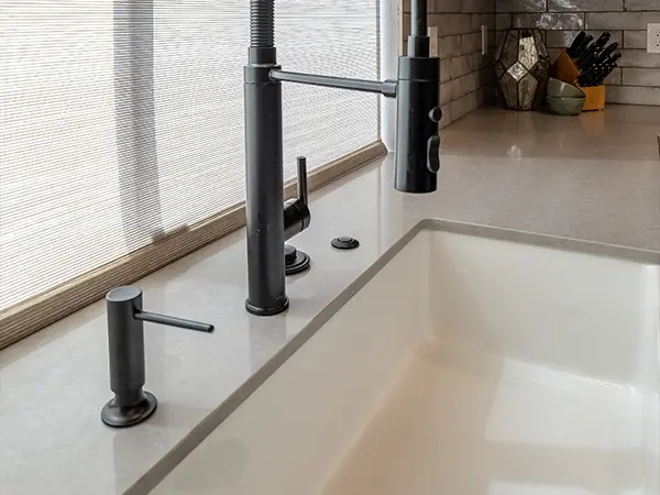 An undermount sink with a black faucet