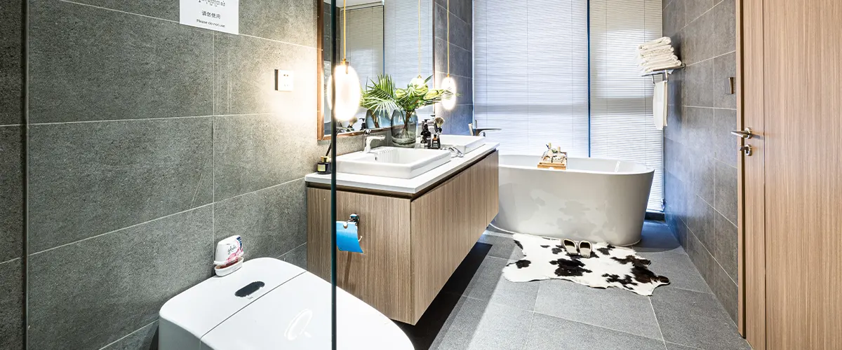 bathroom with grey tile walls and tub