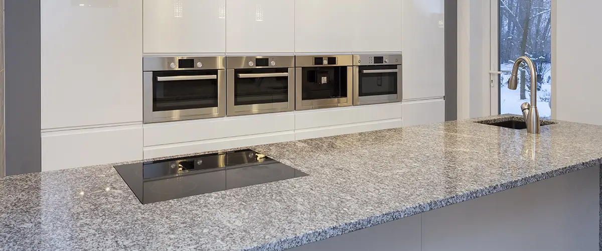 White kitchen with natural stone kitchen countertop materials