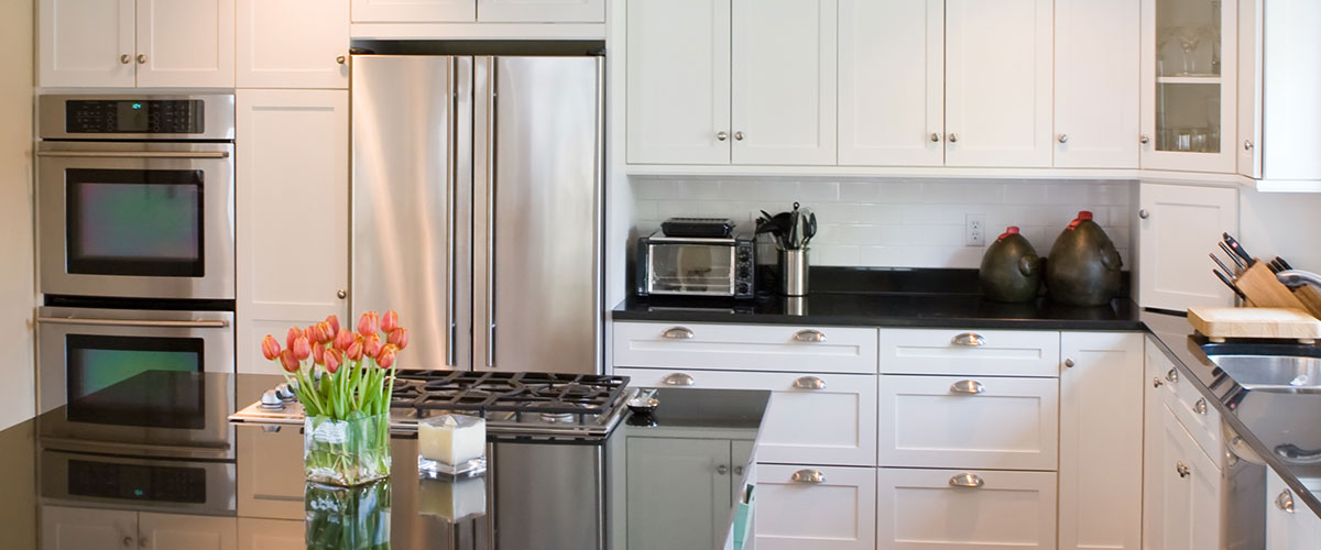 Small kitchen remodeling with white cabinets and sleek appliances