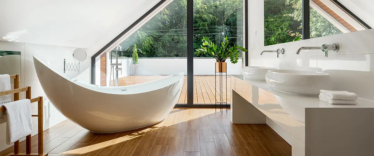 A freestanding tub in a bathroom with LVP flooring and a large countertop