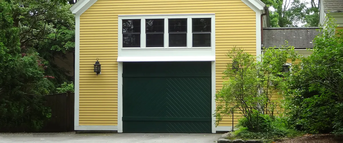A yellow garage addition with a navy blue garage door