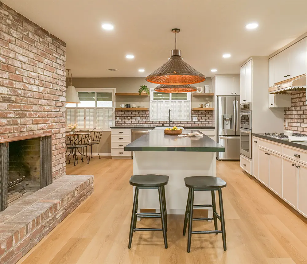 Open space kitchen remodel with fireplace, island, and white cabinets
