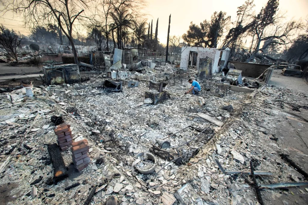 A man looks for belongings in the remains of his home in Altadena, California, on January 9. Ringo Chiu/Reuters