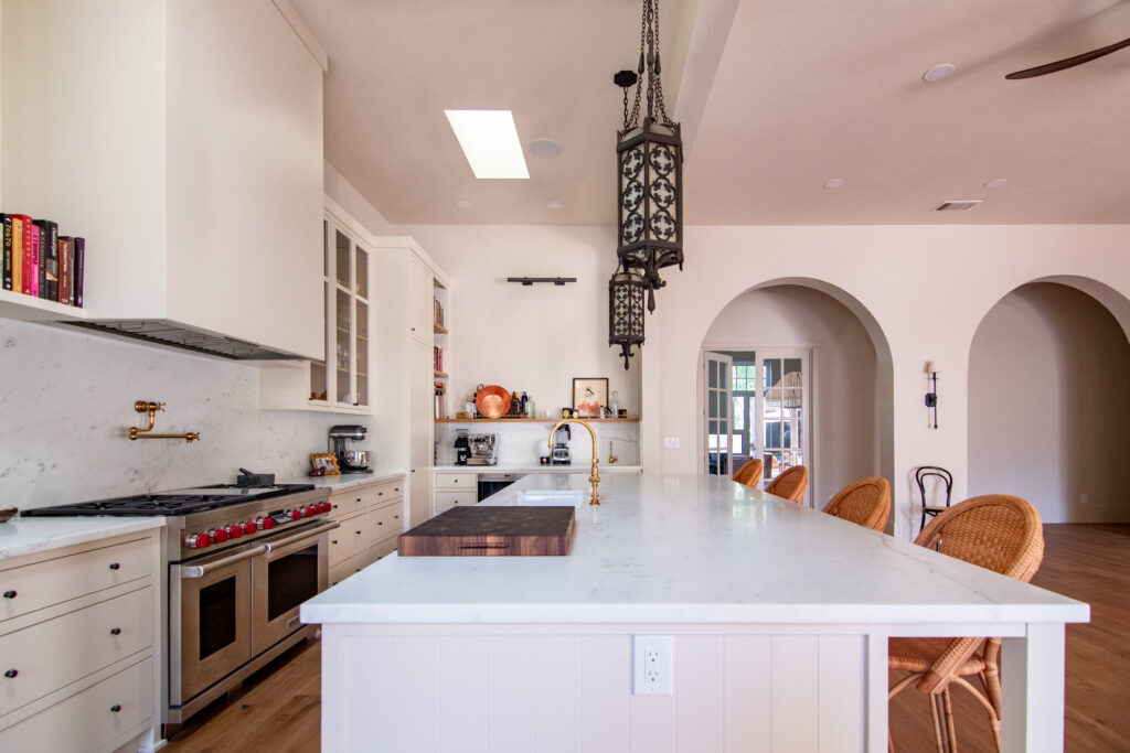 Custom cabinetry and arches connecting the cooking core to the dining room