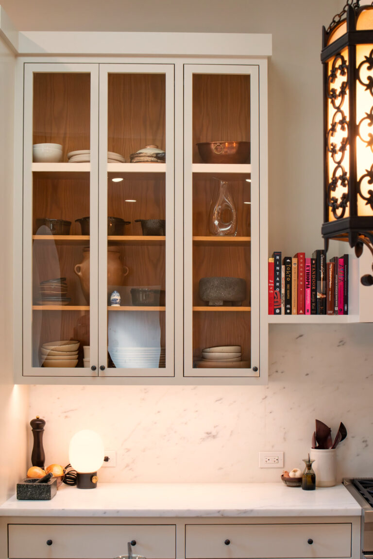Glass-front stemware cabinet lined in white oak
