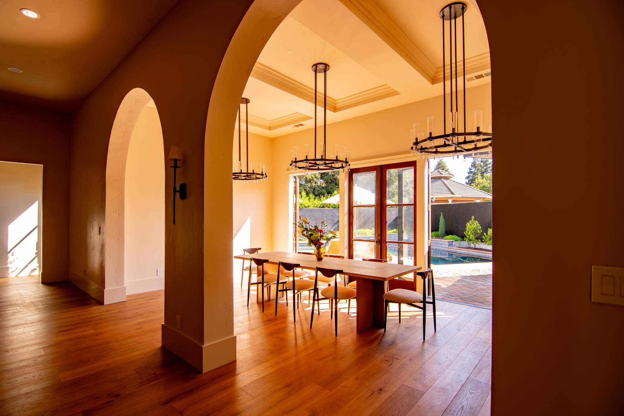 Open-concept kitchen and dining joined by custom framed arches